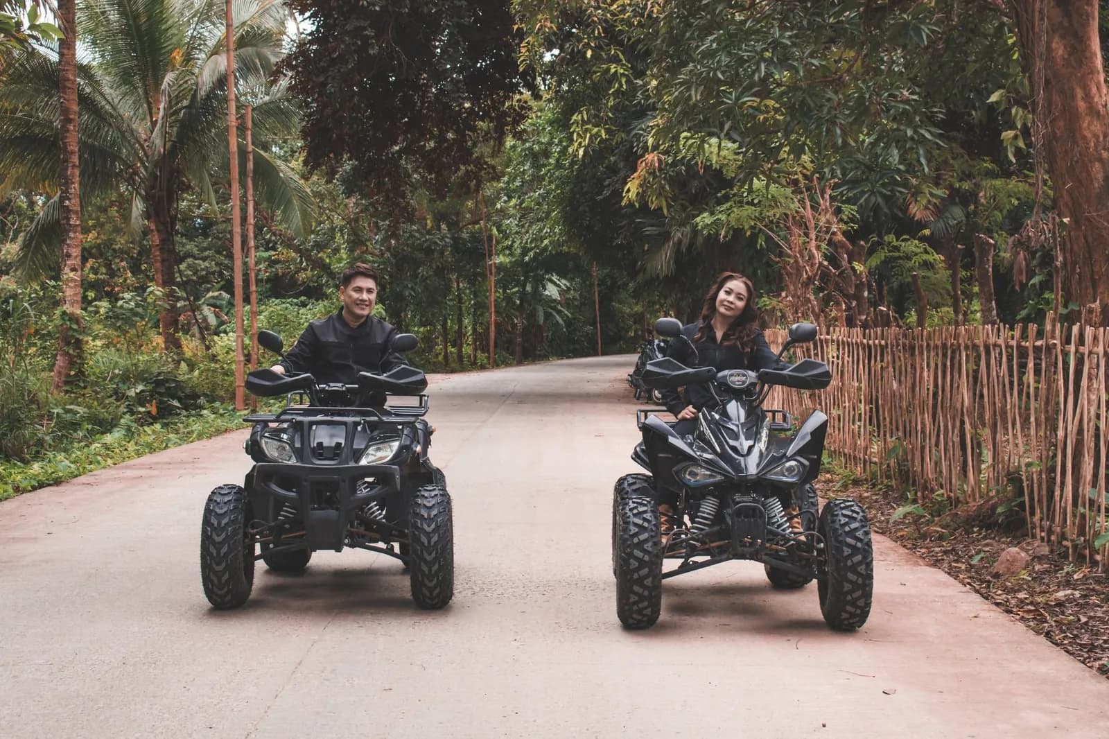 Deux quads sur une route bordée de palmiers et de végétation tropicale
