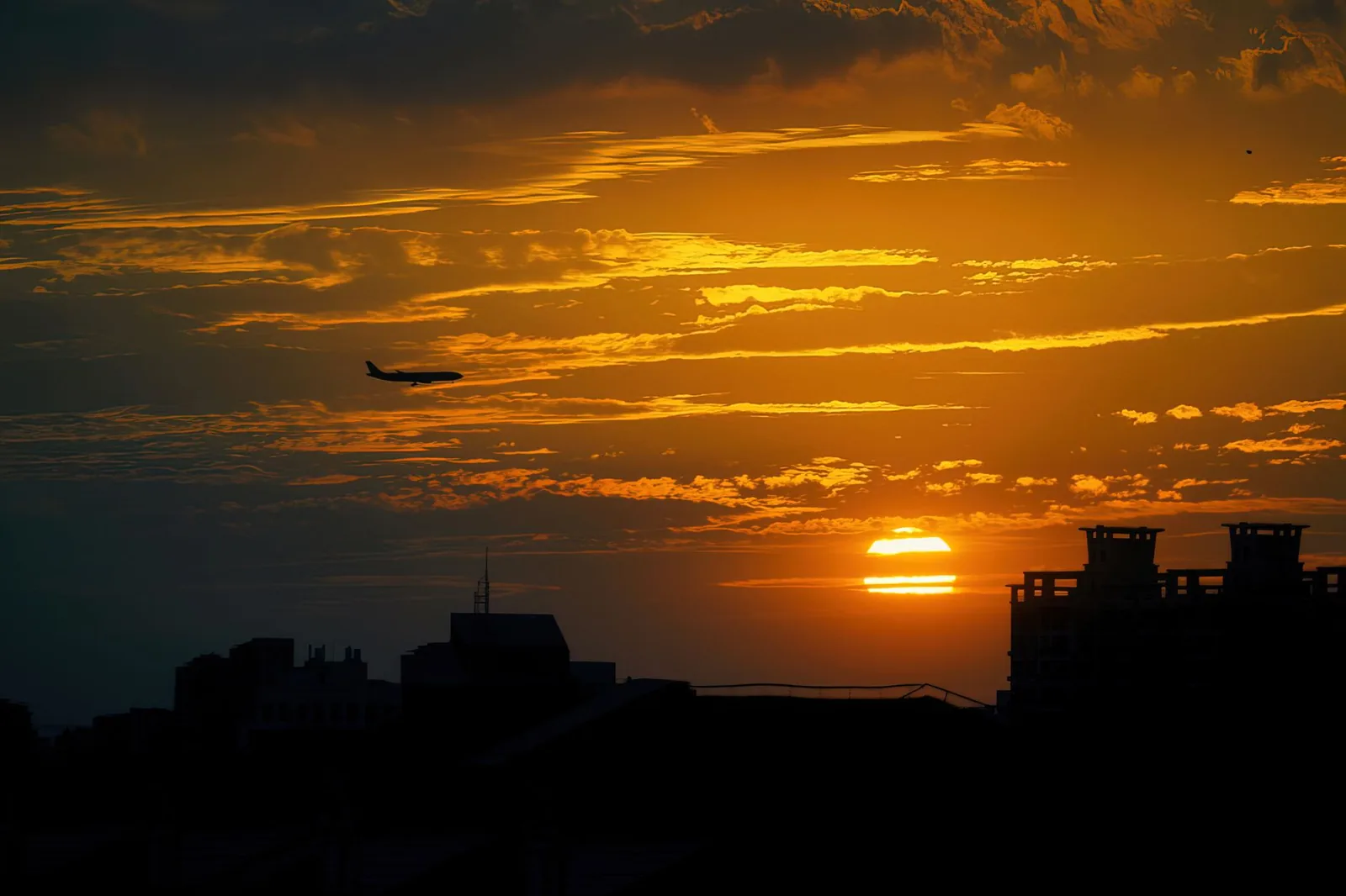 Avion de ligne survolant un ciel doré au coucher du soleil, en route vers Zanzibar