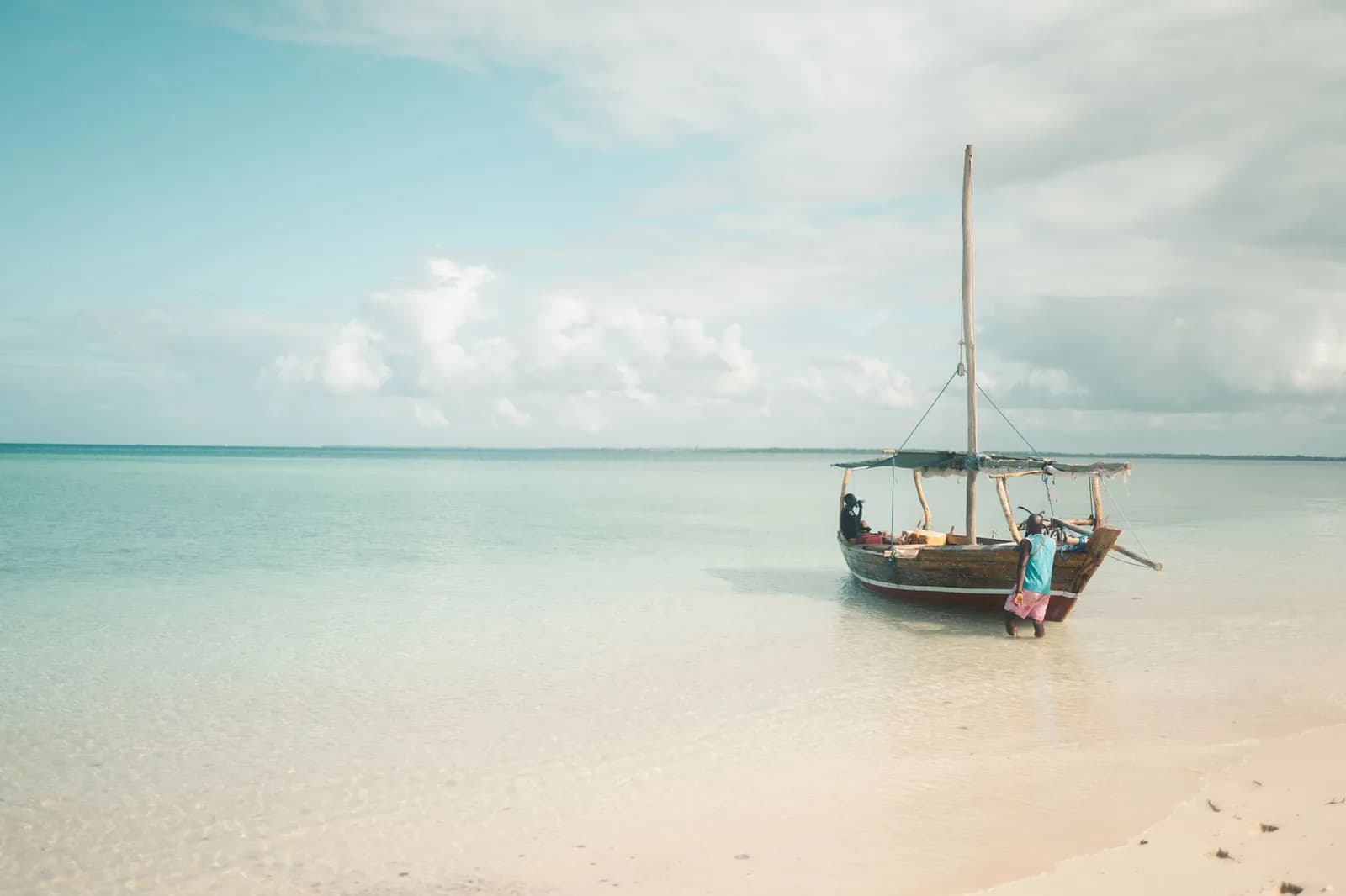 Boutre traditionnel en bois amarré sur une eau turquoise peu profonde à Zanzibar