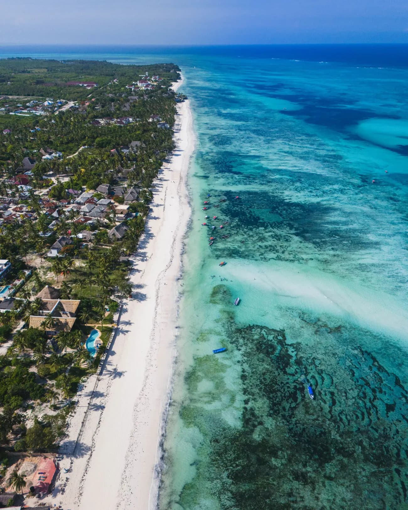 Longue plage de sable blanc et eau turquoise à Kiwengwa, côte est de Zanzibar