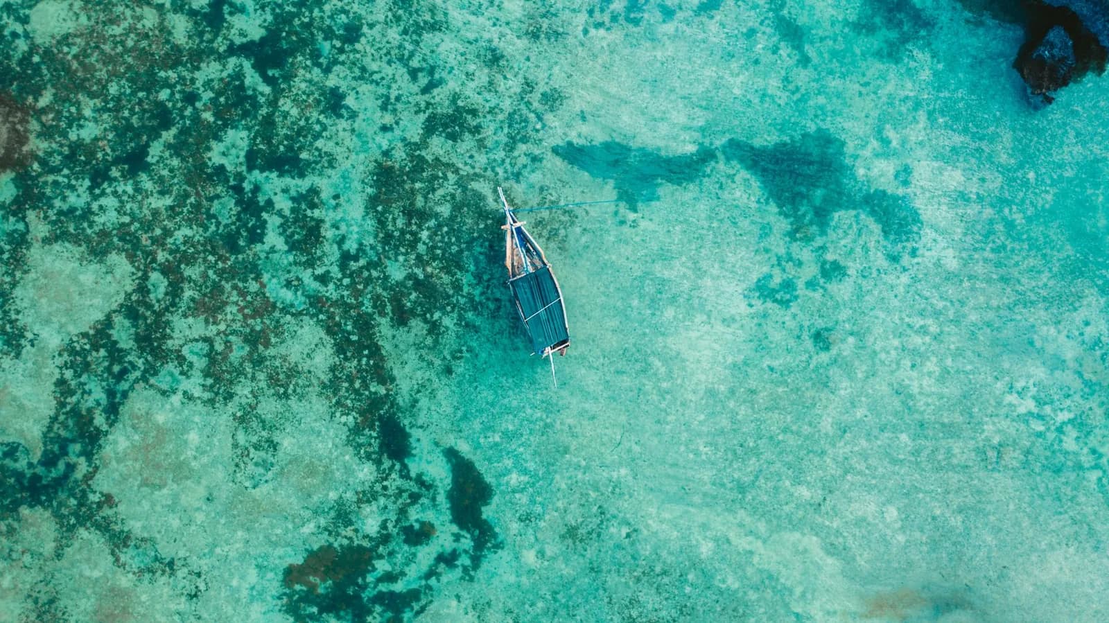 Vue aérienne d'un bateau traditionnel sur le lagon turquoise de Zanzibar