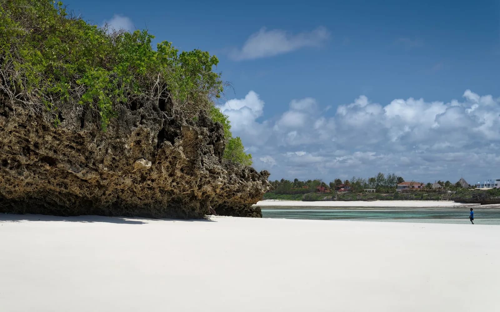 Plage de sable blanc, lagon turquoise et ciel bleu nuageux par temps ensoleillé sur la côte de Zanzibar