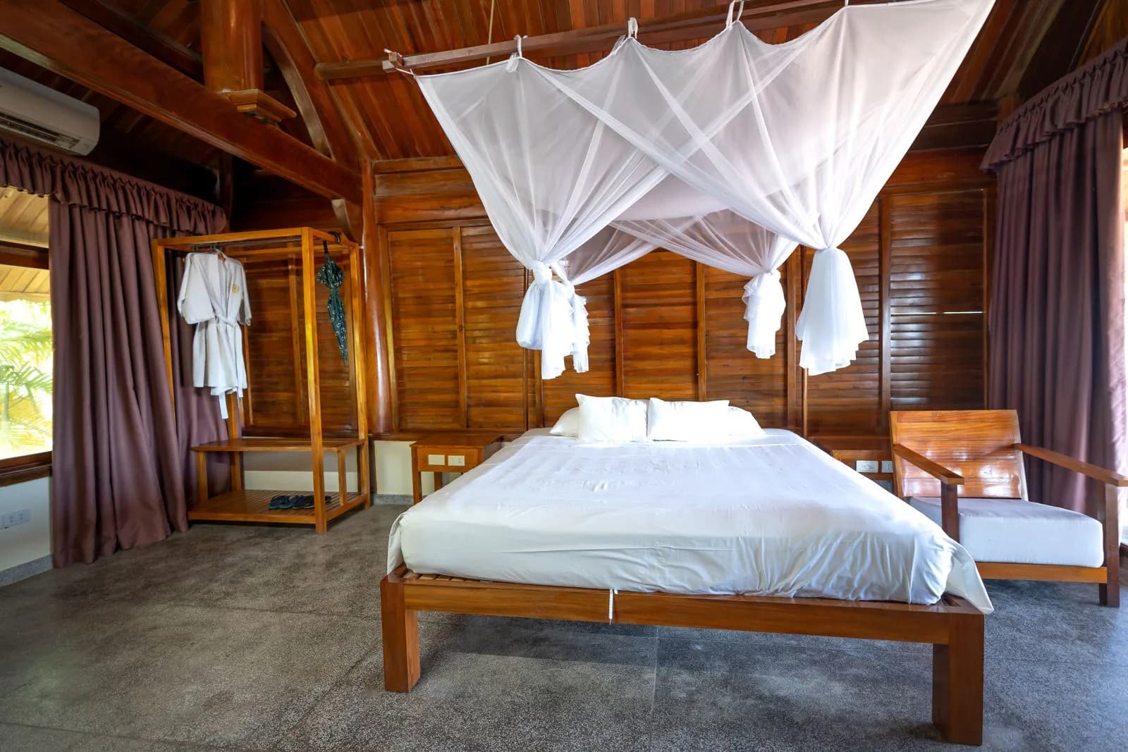 Moustiquaire blanche au-dessus d'un lit dans un lodge tropical