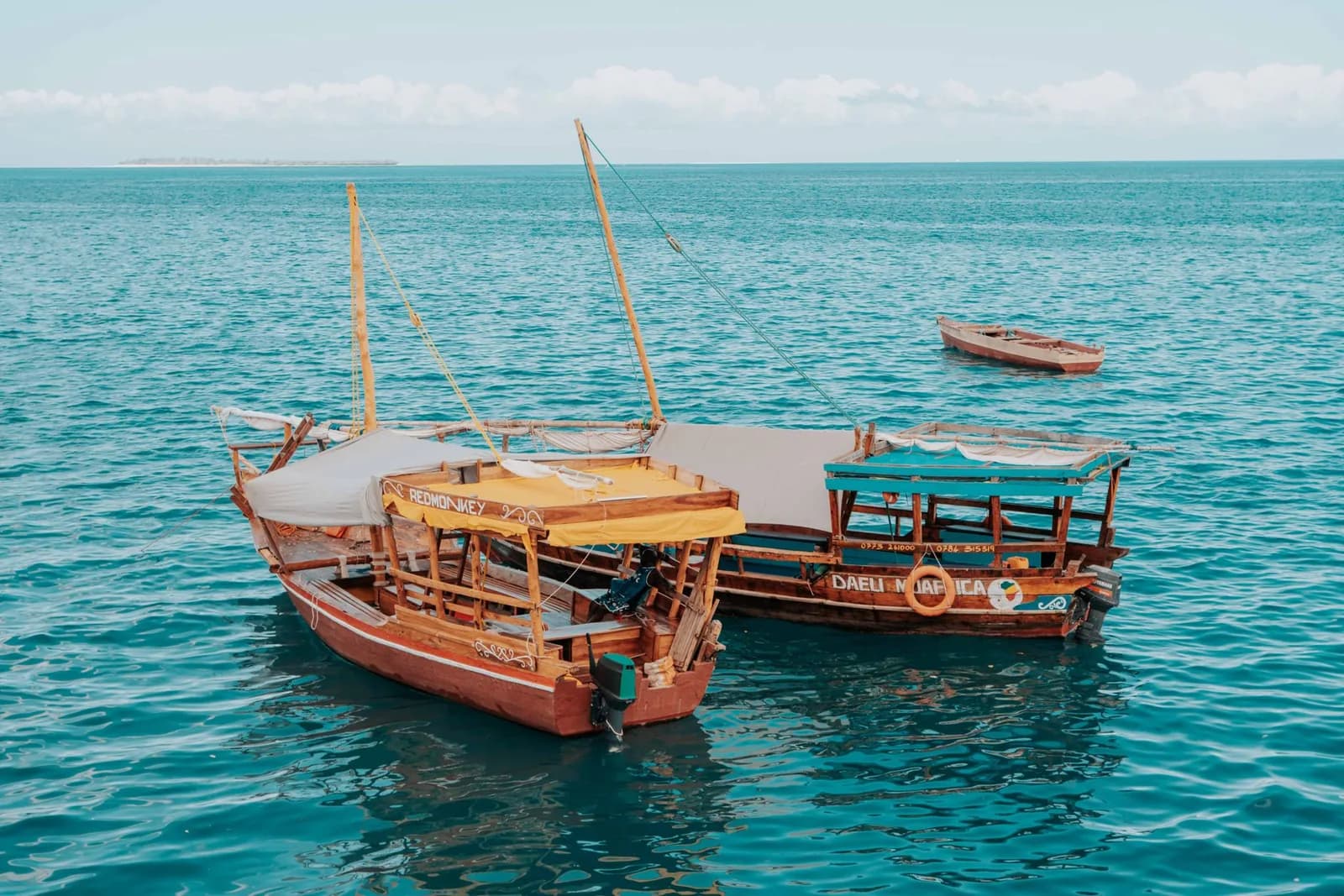 Dhows traditionnels sur une eau turquoise, symbole des excursions à Zanzibar