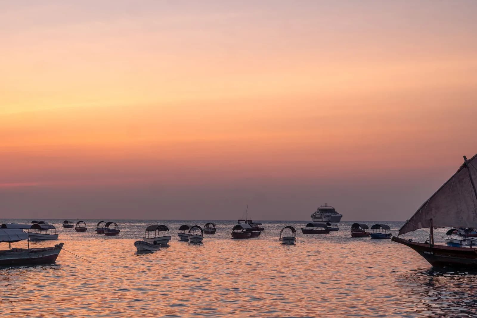 Coucher de soleil sur la baie de Stone Town avec boutres et bateaux ancrés, Zanzibar