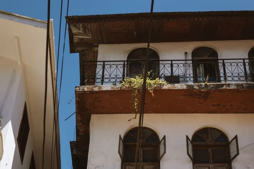 Balcon en fer forgé et avancée de toit en bois sur une maison ancienne de Stone Town, Zanzibar